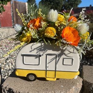 Ceramic camper. 11” filled with sola wood flowers and faux greenery.